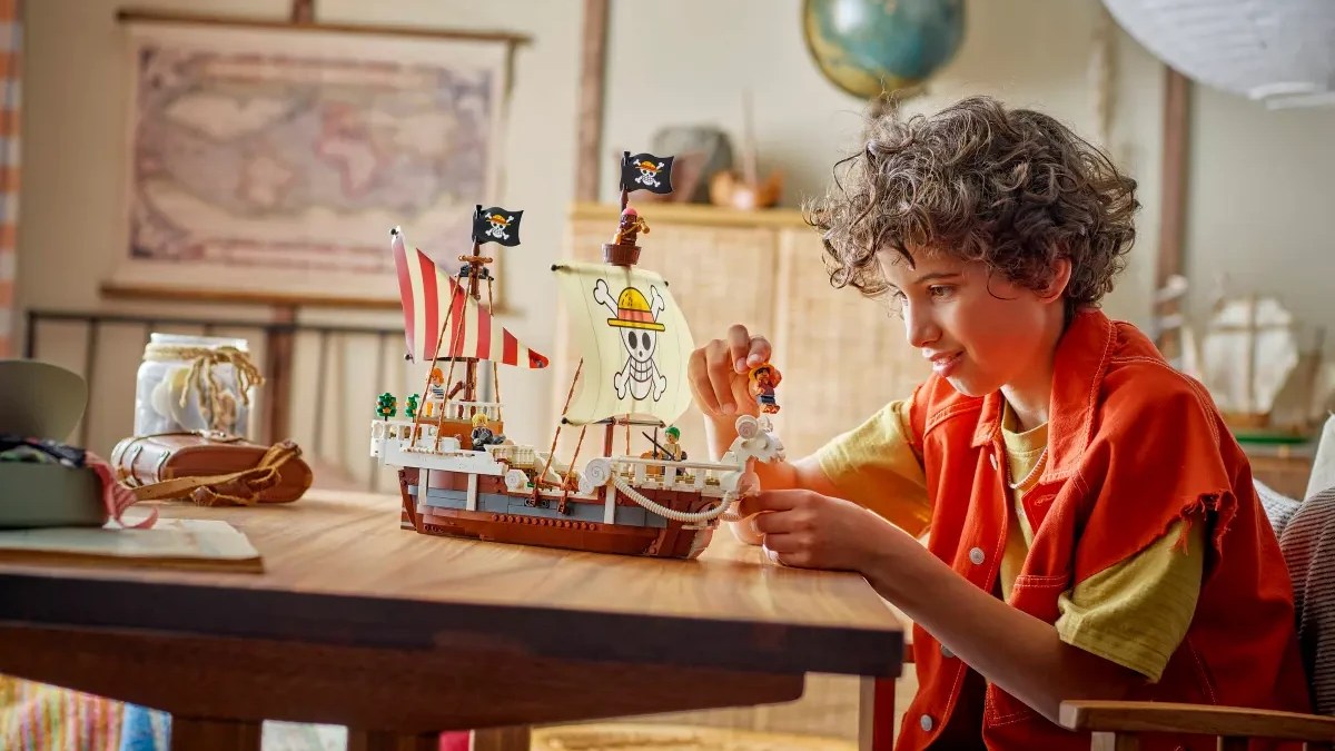 A boy playing with a toy ship